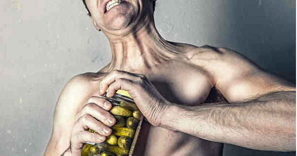 frustrated man opening pickle jar