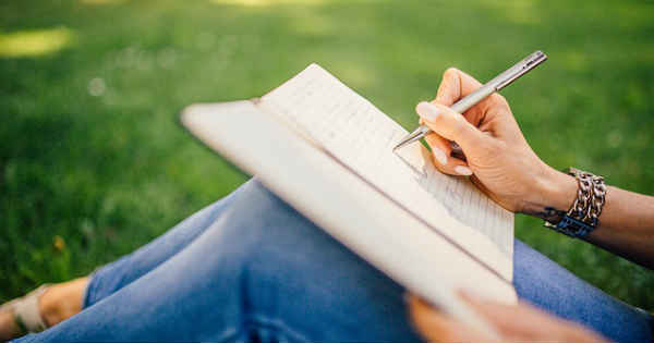 woman writing in her journal in the park